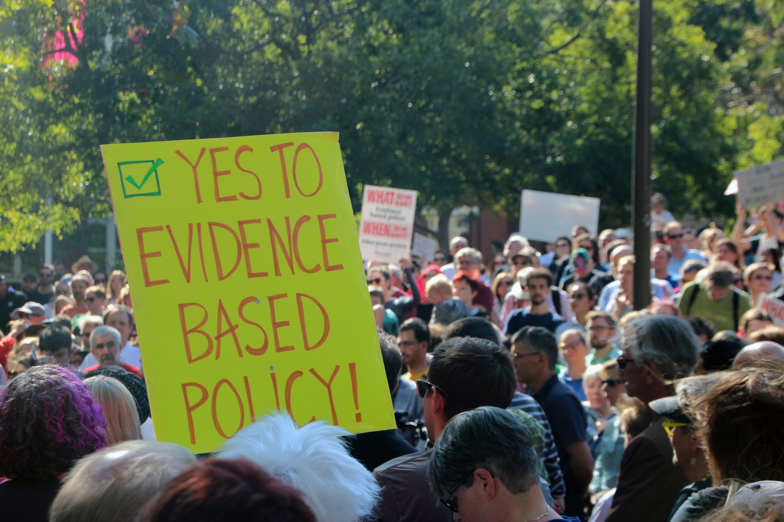 Protest with sign reading YES TO EVIDENCE BASED POLICY!