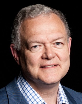 Man in a suit with blue check shirt.