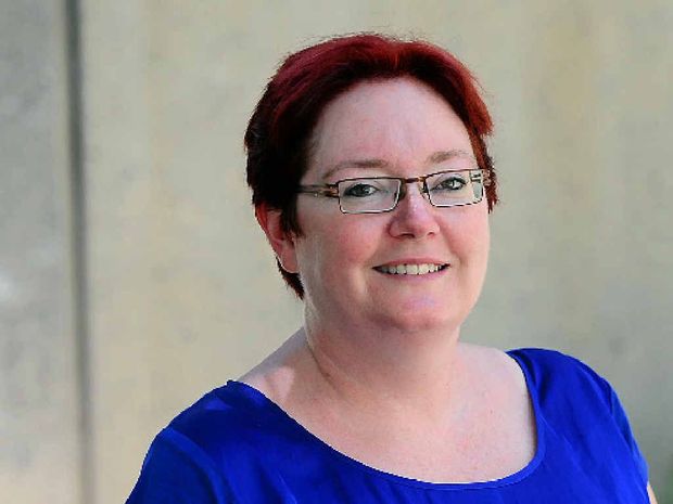 Woman wearing glasses and a bright blue shirt.